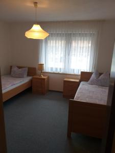 ein Hotelzimmer mit zwei Betten und einem Fenster in der Unterkunft Kaufhaus Feldberg in Rinken