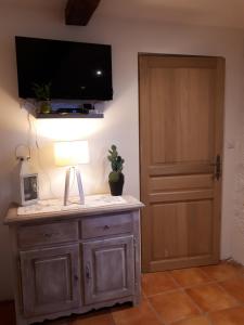 Zimmer mit einem Tisch mit einer Lampe und einer Tür in der Unterkunft Studio Le clos des vins d'Anges in Saint-Pierre-des-Champs