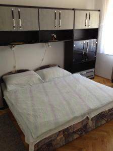 1 dormitorio con 1 cama grande y armarios blancos y negros en Rozs Ház, en Zalakaros