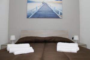 a bedroom with a bed with a painting of a pier at Dea House Airport in Naples