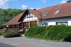 a large house with a brown roof at Hotel am Steinertsee - Kassel-Ost in Kaufungen