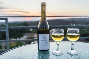 a bottle of wine and two glasses on a table at Amalia Panorama House in Zanaja