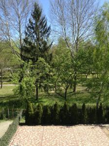 un jardín con árboles y una pasarela de ladrillo en Rozs Ház, en Zalakaros