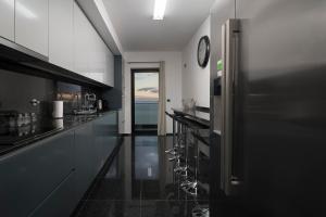 フンシャルにあるVILLA PARADISE - Modern and Sophisticatedの黒いカウンターと壁掛け時計付きのキッチン