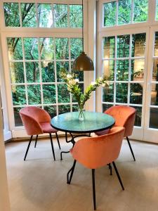 una mesa con sillas y un jarrón con flores. en The Suites Alster Waterfront Family Apartments, en Hamburgo