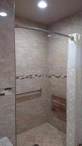 y baño con ducha y puerta de cristal. en Santa Ana Travel Inn, en Santa Ana
