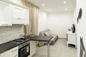 a kitchen with white cabinets and a stove top oven at Eur Home in Rome