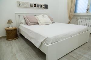 uma grande cama branca num quarto com uma janela em Eur Home em Roma