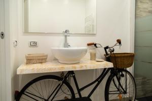 a bathroom with a sink and a bike on a counter at Eur Home in Rome +9 photos