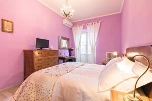 una camera da letto con pareti viola, un letto e una TV di A Roman Tale B&B a Roma