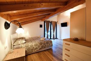1 dormitorio con 1 cama en una habitación con techos de madera en Il Gelsomino, en Ornavasso