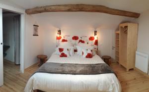 a bedroom with a large white bed with red pillows at La chenevière in Saint-Rémy-de-Chargnat