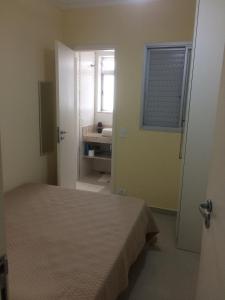 1 dormitorio con 1 cama y baño con lavamanos en Apto Novo a uma Quadra da Praia en Guarujá