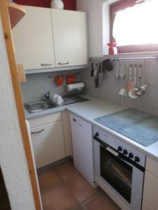 a kitchen with white cabinets and a sink and a stove at Bergsee in Schluchsee