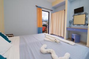 a bedroom with a large bed with towels on it at Kalypso Studios & Apartments in Karavomylos