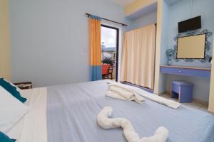 une chambre avec un grand lit avec des serviettes dessus dans l'établissement Kalypso Studios & Apartments, à Karavomylos
