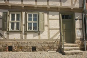 a building with a green door and windows at Urlaub im Fachwerk - Klink in Quedlinburg