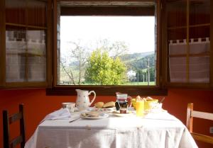 a table with a plate of food and a window at Hotel Rural Suquin in Navia