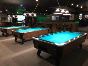 three pool tables in a room with a bar at Westwind Motor Inn Hotel in Drayton Valley