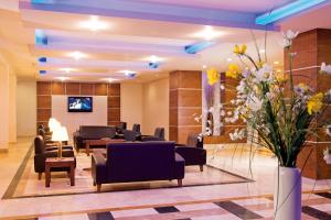 een wachtkamer met stoelen en bloemen in de lobby bij Mom Hotel in Izmir