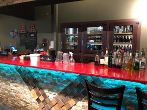 a bar with a red counter and some bottles of alcohol at Westwind Motor Inn Hotel in Drayton Valley