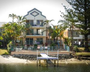 a building with a dock in the water in front at Surfers Riverside in Gold Coast