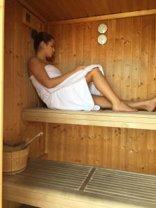 a woman is sitting in a sauna at Hotel Don Pedro in Ischia