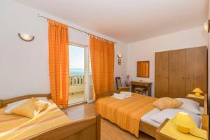 a bedroom with two beds and a large window at Apartments Tonci in Duće