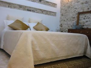 una camera da letto con letto, lenzuola e cuscini bianchi di La casa del Largo a Venosa