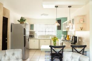 a kitchen with a refrigerator and two chairs at CASA CACTO en San Jose del Cabo in San José del Cabo