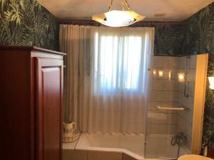 a bathroom with a shower with a shower curtain at Le Clos des Lys, Maison de Pays Raffinée Proche de la Mer, Linge Inclus in Saint-Georges-dʼOléron +34 photos