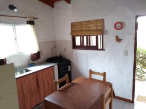 a kitchen with a wooden table and a sink at Los abedules in Capilla del Monte
