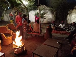a group of people standing around a fire at Nature Trail camps & Homestay in Jodhpur