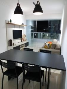 una mesa de comedor negra y sillas en la sala de estar en NOVO EDIFICIO VIENA - ATRAS do PRAIA CENTER en Guarapari