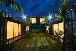 a courtyard of a house at night with lights at HiddenBOX in Nakhon Nayok