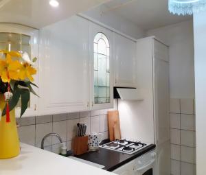 a kitchen with white cabinets and a stove top oven at My Miracle Apartment in Zagreb