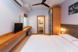 a bedroom with a bed and a flat screen tv at Gala Villa Pattaya in Pattaya South +31 photos