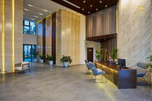 a woman sitting at a desk in a lobby at Mandala Hotel & Spa Bac Ninh in Bắc Ninh
