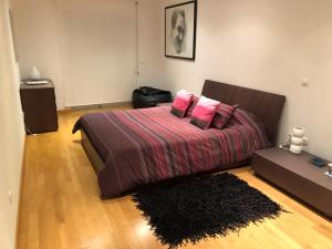 Un dormitorio con una cama con almohadas rosas y una alfombra. en Your place in Faro, en Faro