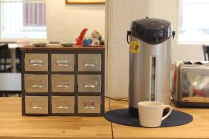 a coffee machine sitting next to a cup on a counter at Norn Yaowarat Hotel in Bangkok