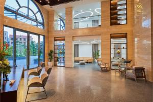 a lobby with chairs and tables in a building at Mandala Hotel & Spa Bac Ninh in Bắc Ninh