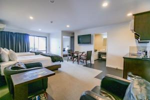 Habitación de hotel con cama y sala de estar. en Aotea Motor Lodge en Whanganui