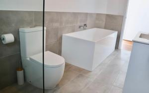 a bathroom with a white toilet and a sink at By Moonlight in Wattle Hill