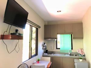 a kitchen with a flat screen tv on the wall at Chaniva-Joy Island View Appartments in Malapascua Island