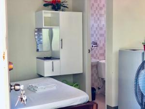 Habitación con cama y armario blanco en Chaniva-Joy Island View Appartments, en Isla de Malapascua