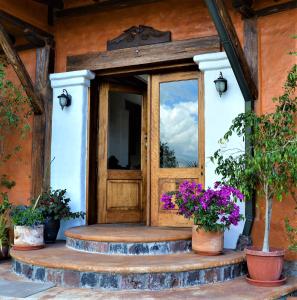 una entrada a una casa con puerta de madera en Ilatoa Lodge, en Quito