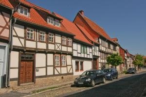a row of houses with cars parked on a street at Urlaub im Fachwerk - Das Sattlerhaus in Quedlinburg