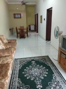 a living room with a couch and a tv at Homestay Amsyarah in Seri Iskandar