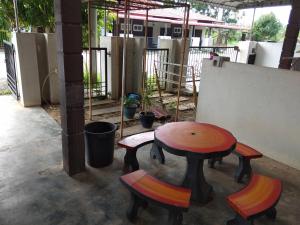 a table and two chairs and a table and a table at Homestay Amsyarah in Seri Iskandar
