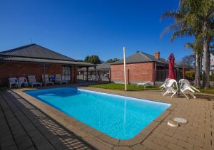 Centretown Motel في ناجامبي: مسبح مع كرسيين ومنزل